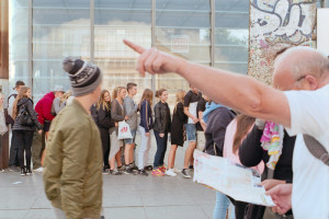 Berlin Touristen mit Stadtplan und Schulklasse vor Mauerresten am Potsdamer Platz